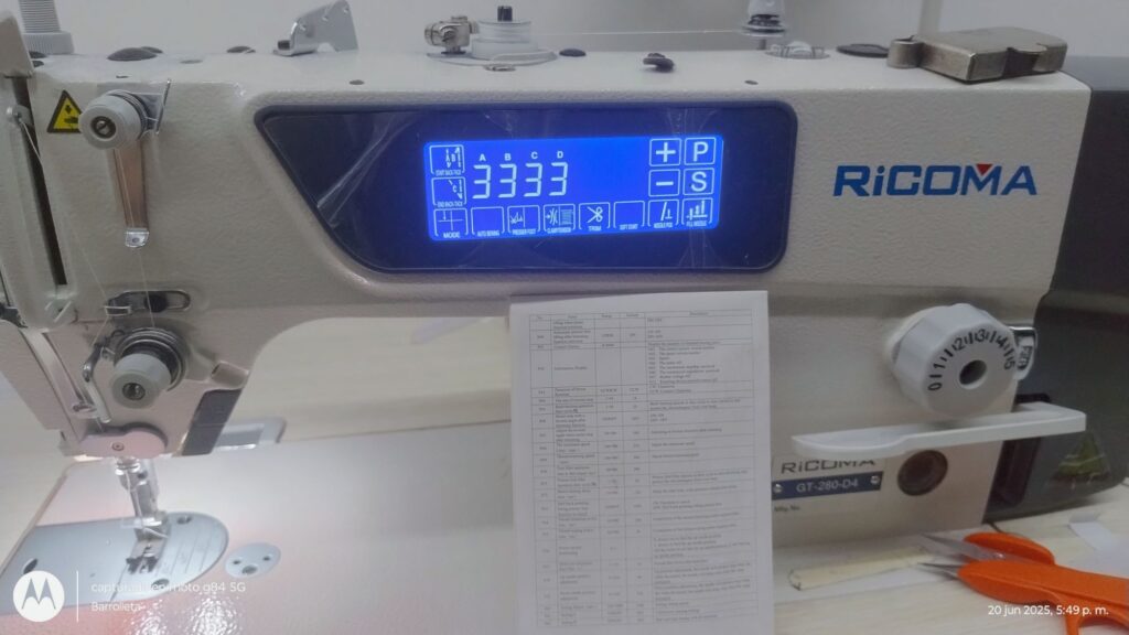 Máquina de bordar Ricoma GT-280-D4 con pantalla digital mostrando configuraciones y una hoja de instrucciones en español.